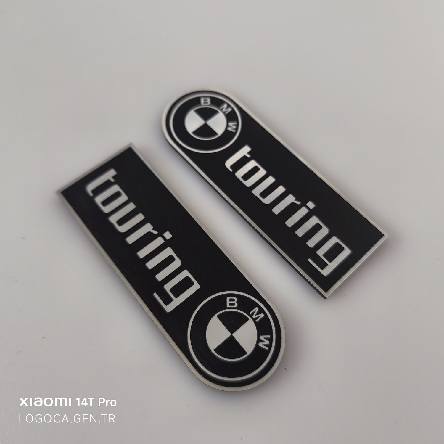 BMW Touring Bir Tarafı Yuvarlak Siyah Üzeri Gümüş Yazılı Plastik Etiket (10x3,5cm)